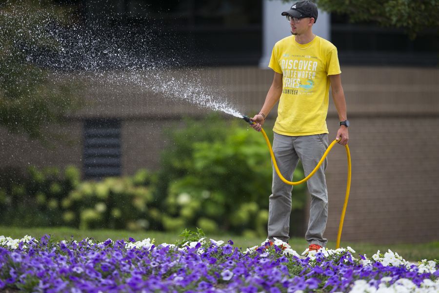 Student watering flowers.