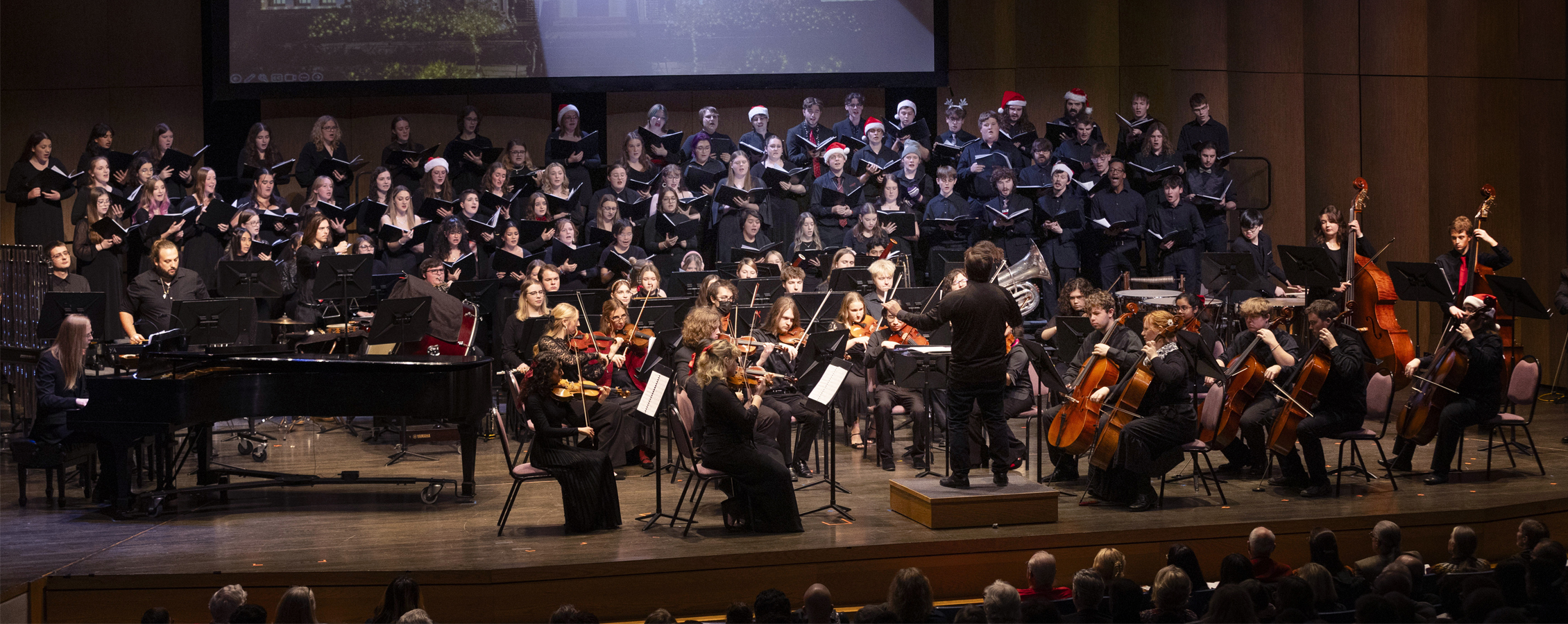 A faculty member conducts orchestra at music gala.
