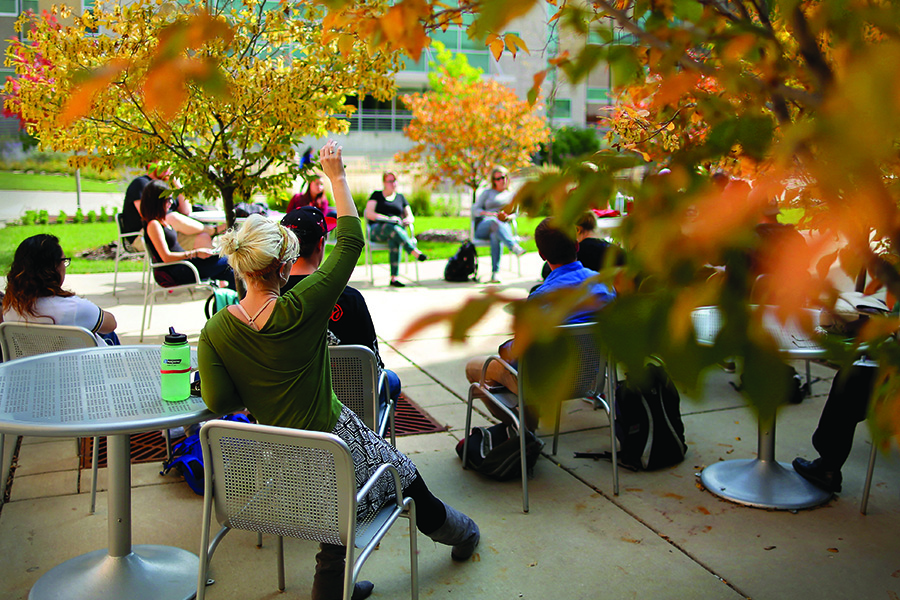 Students have class outside among fall colors.