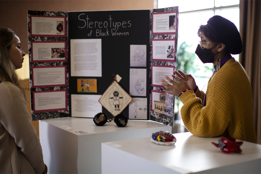 A student explains their research at undergraduate research day.