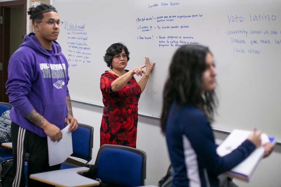 A Spanish faculty member teaches at a whiteboard.