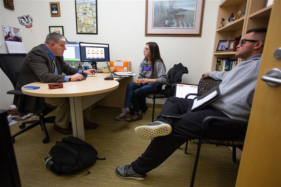 Three people sit together in an office.