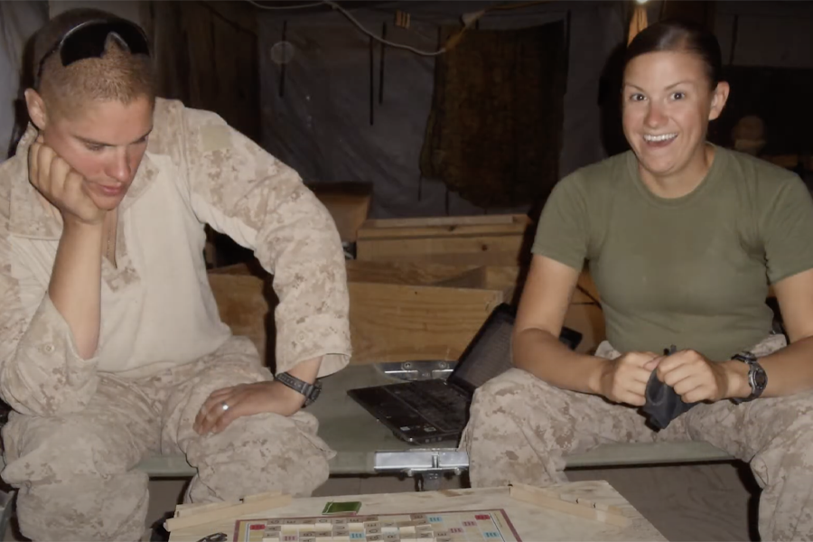 Kim Neville plays a board game with a fellow soldier.