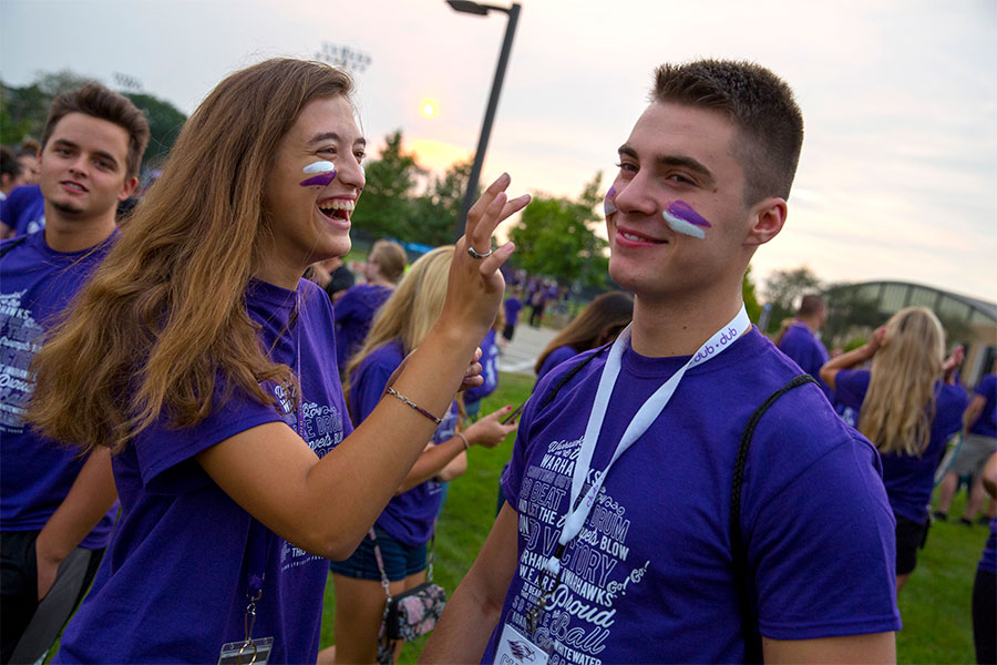 Students apply facepaint during a welcome rally.