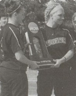Members of the 2008 softball team posing with trophy