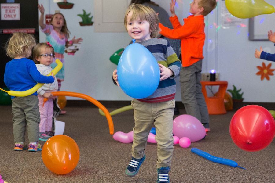 Children playing with balloons at Andersen Library stuffed animal sleep over event