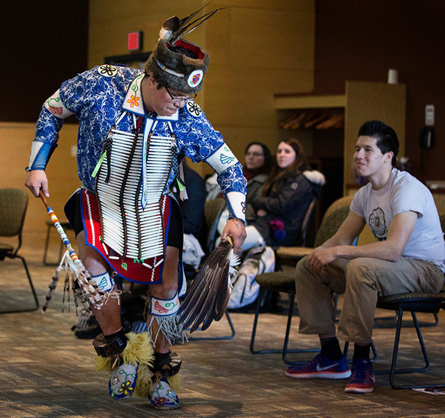 A Red Cliff member performs a hunting dance.