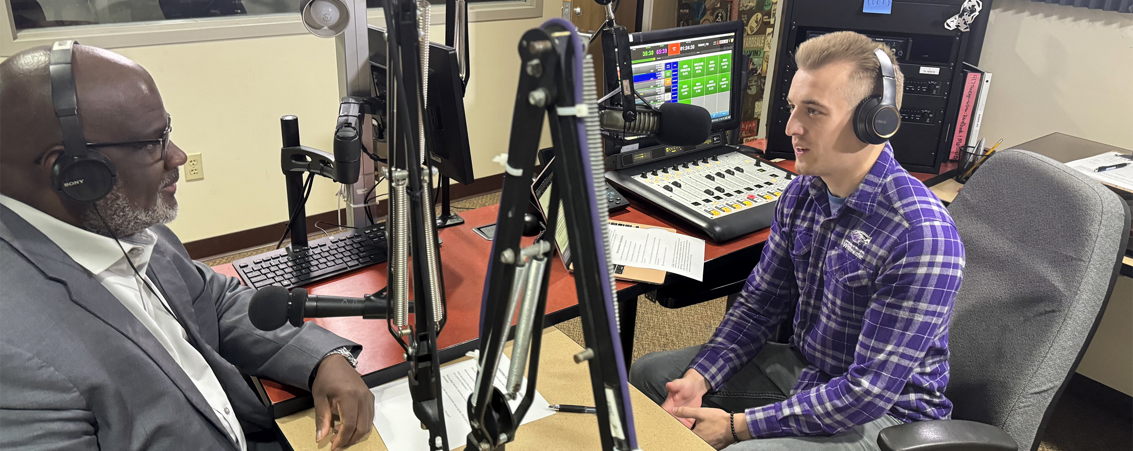 A student interviews Chancellor King in a radio booth.