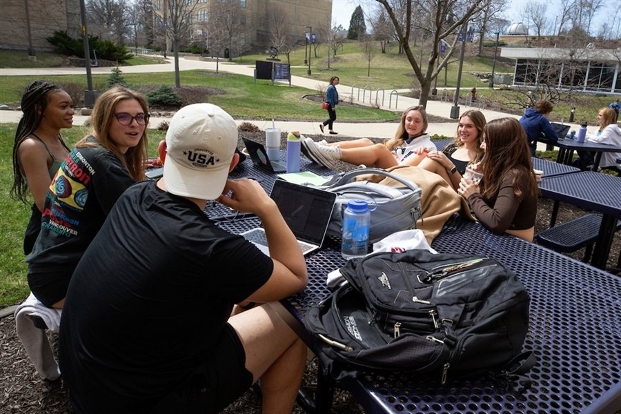 A group of people sit at a table outside.