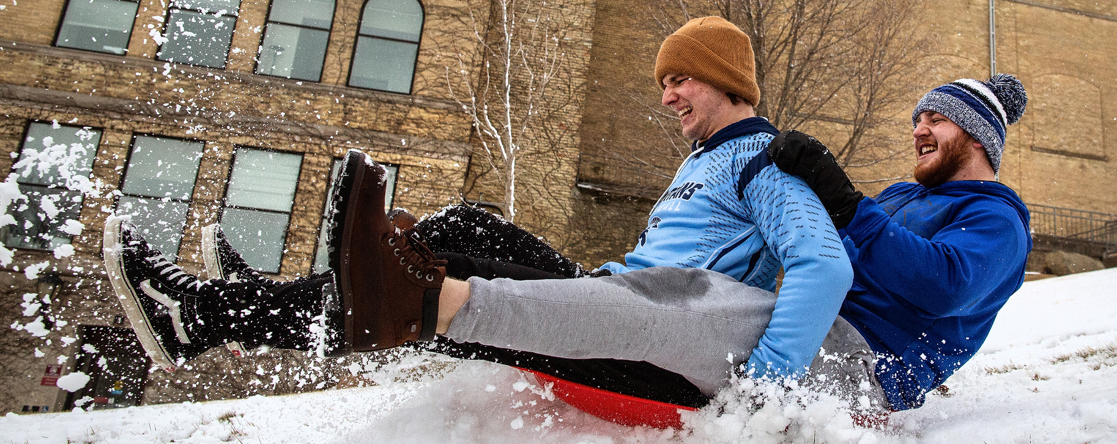 Two students sled down the hill next to Hyer Hall.