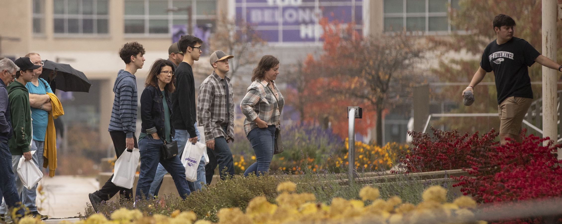 A group of people touring campus are about to enter McGraw Hall.