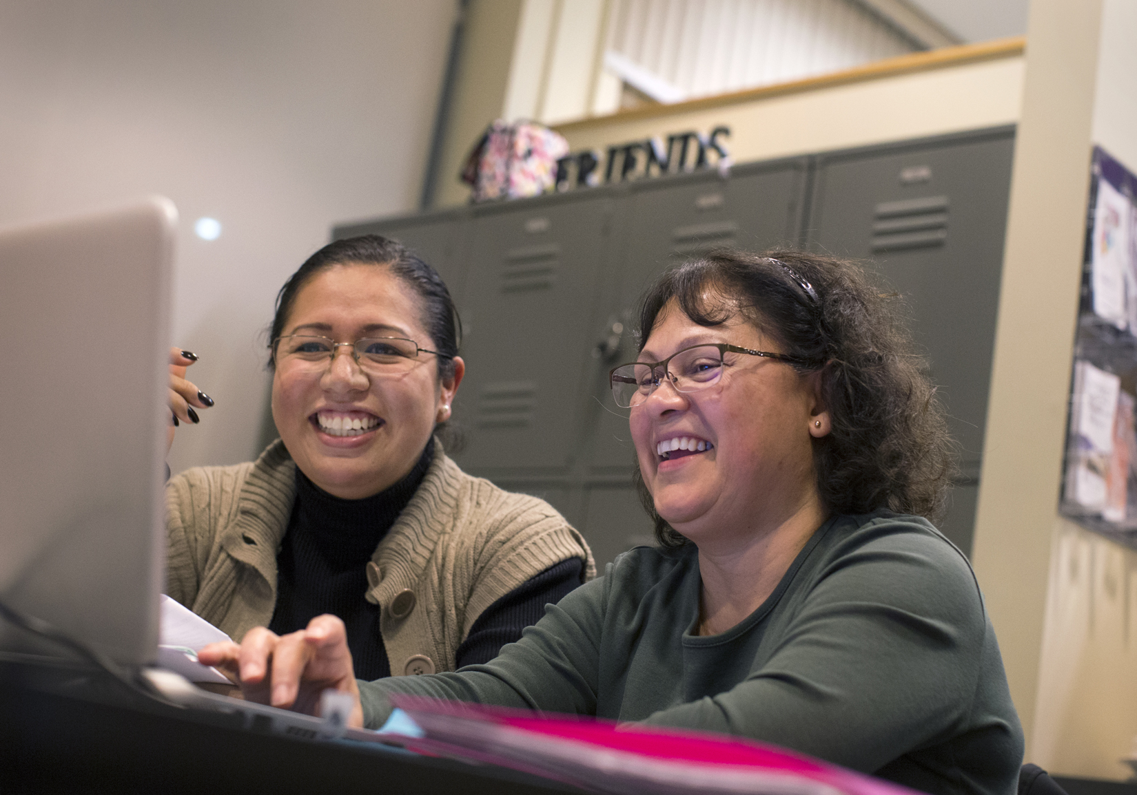 Rocio Aburto and Adelaida Sisk smiling and looking at a laptop screen