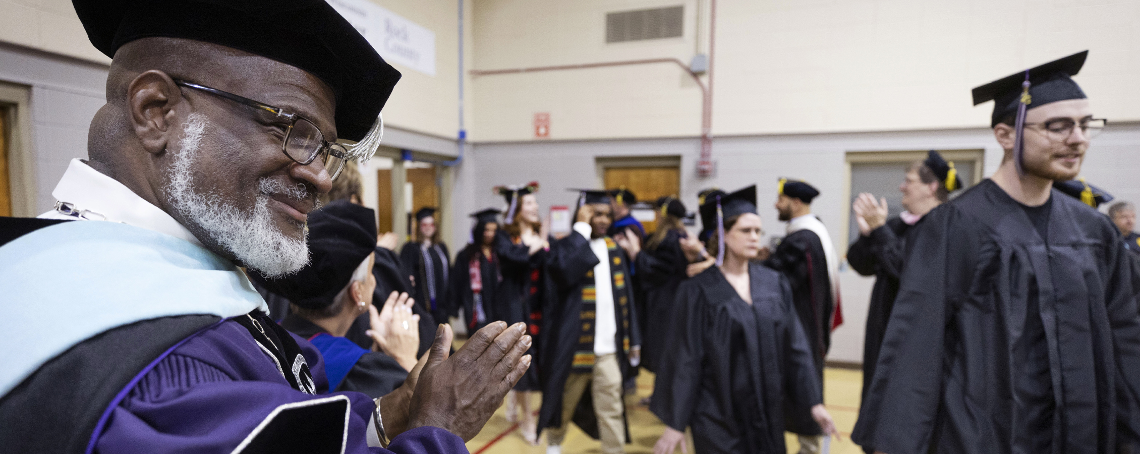 Chancellor Corey King speaks at a podium with the American flag in the background.