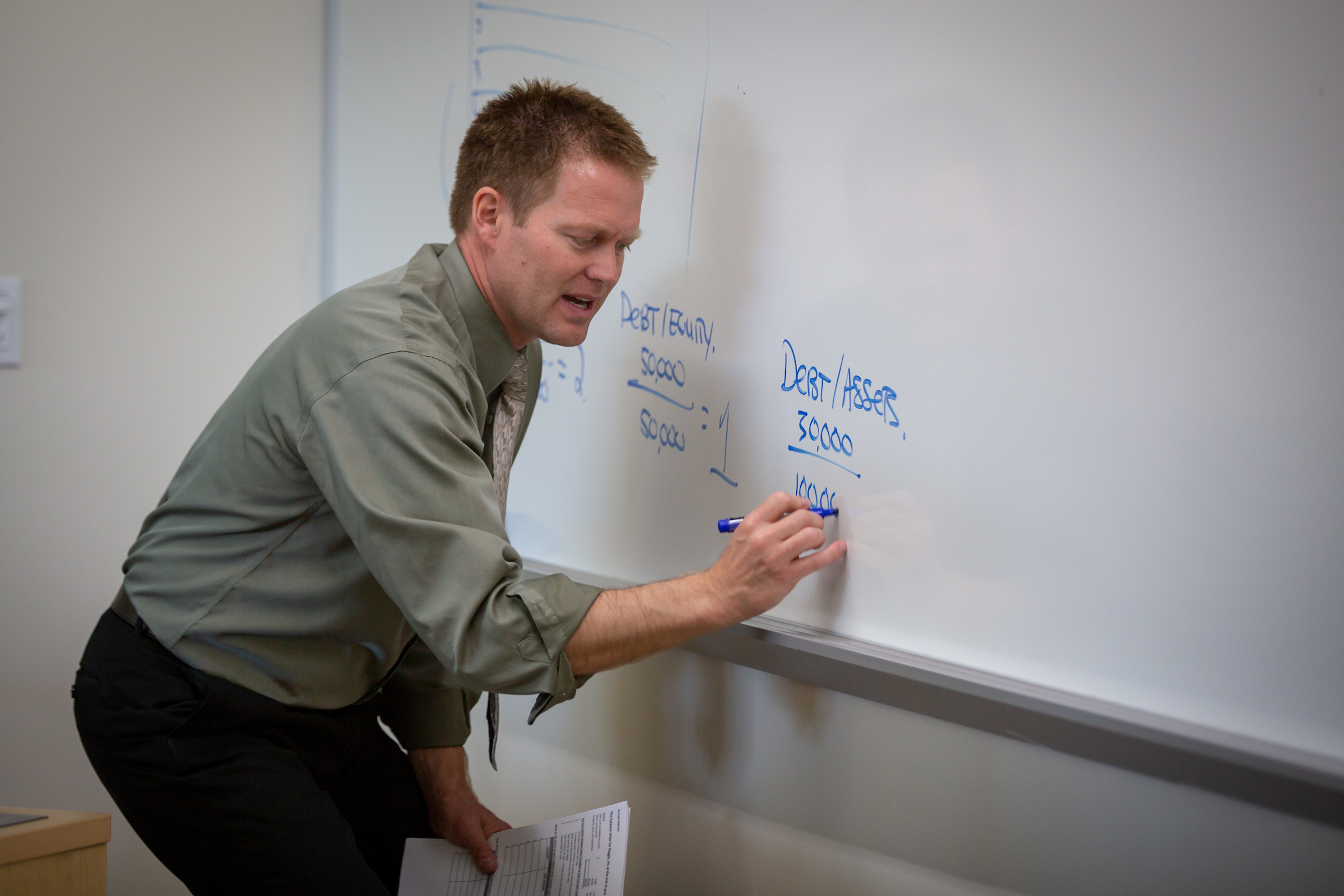 Professor writing on whiteboard