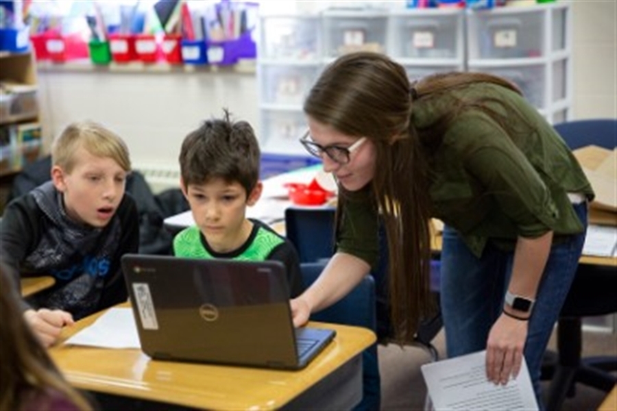 Teacher helping student with computer work