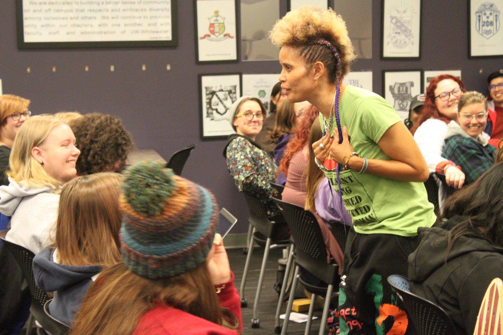Staceyann Chin walks down an aisle of students in the Warhawk Connection Center while reading from her memoir. 