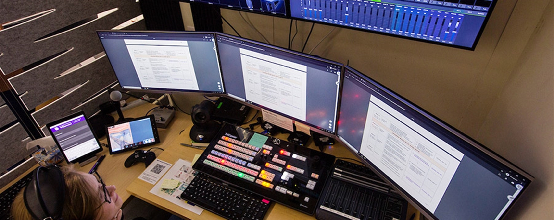 A student looking at three monitors doing work