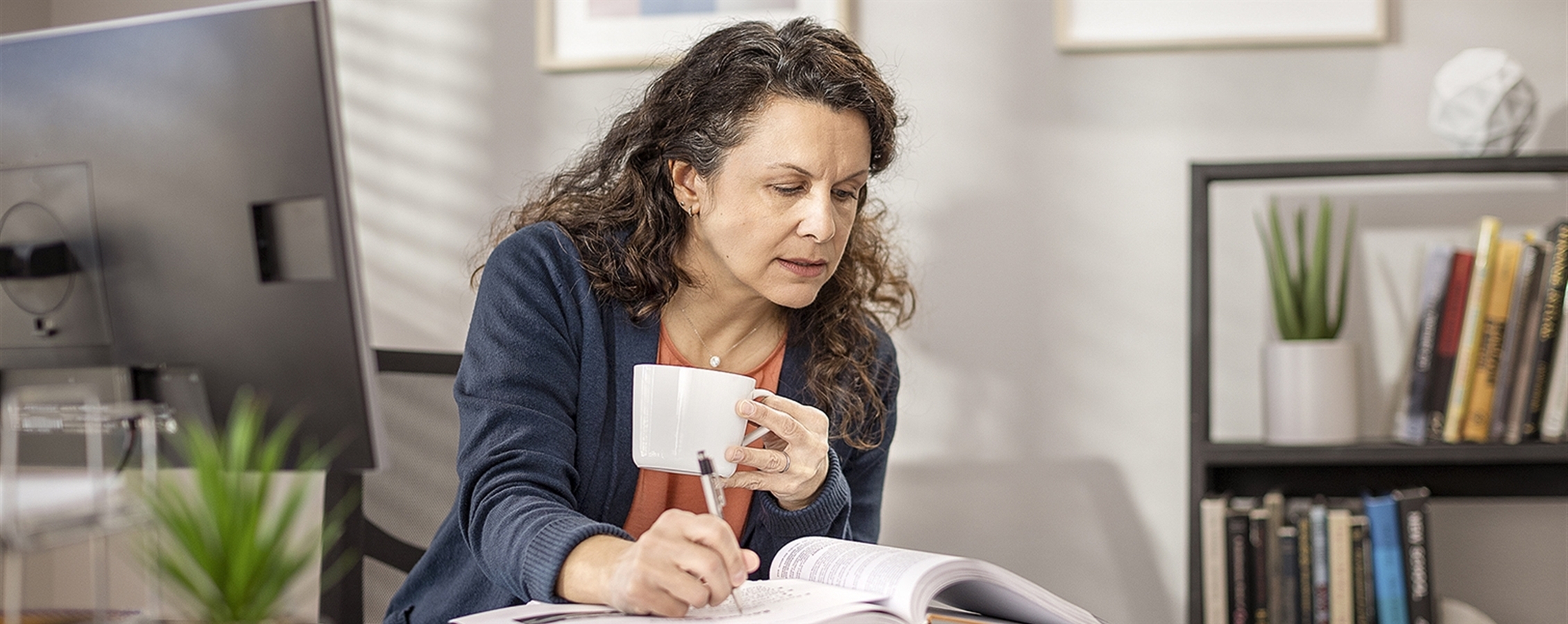 Student drinks from a mug while working at home