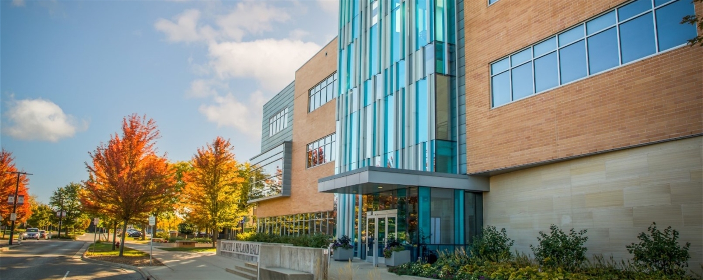 Outside photo of Hyland hall with fall trees in the backgrounds