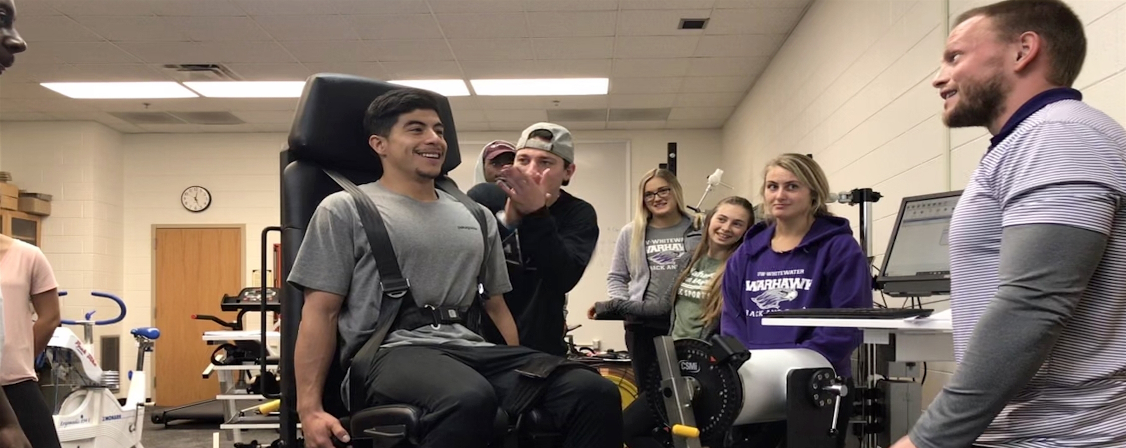 A faculty member stands with students during an exercise in a kinesiology class.