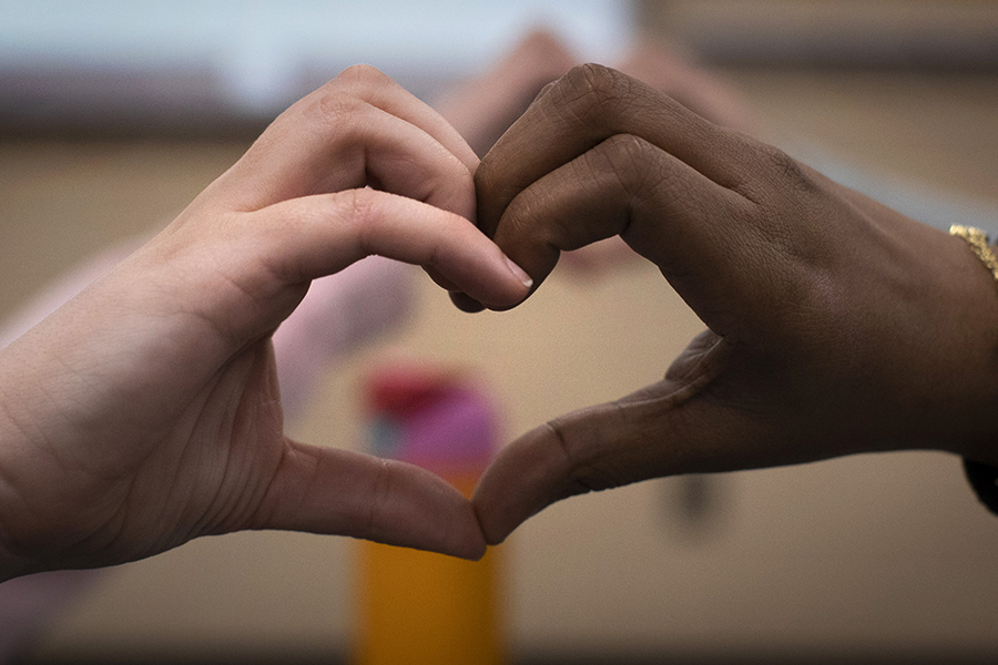 Two hands come together to form a heart shape.