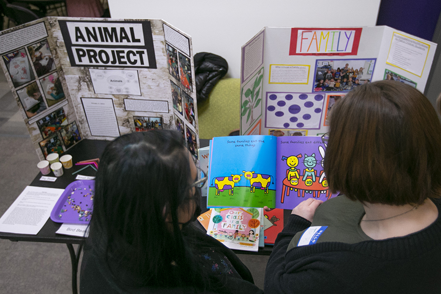 Two people look through a colorful children's book.