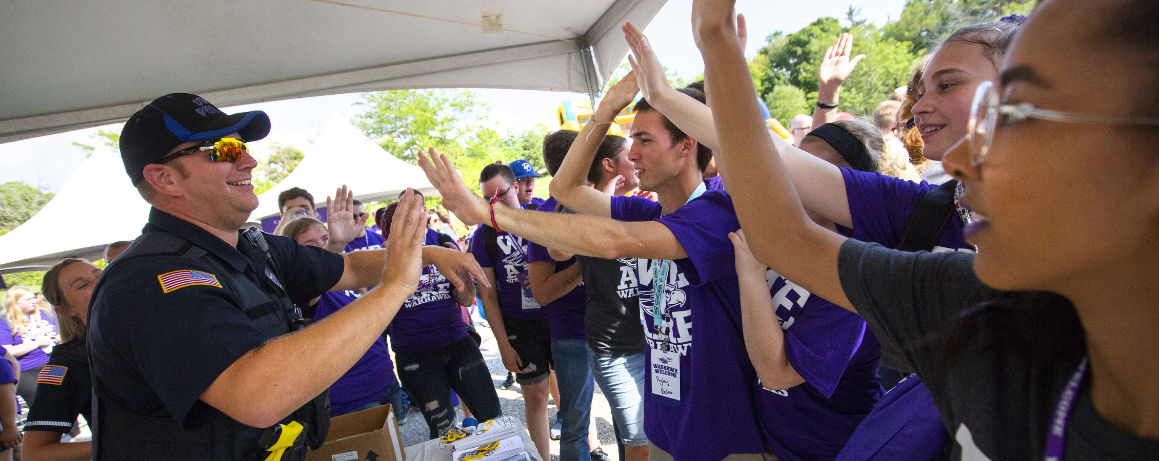 A UW-Whitewater police office high fives students.