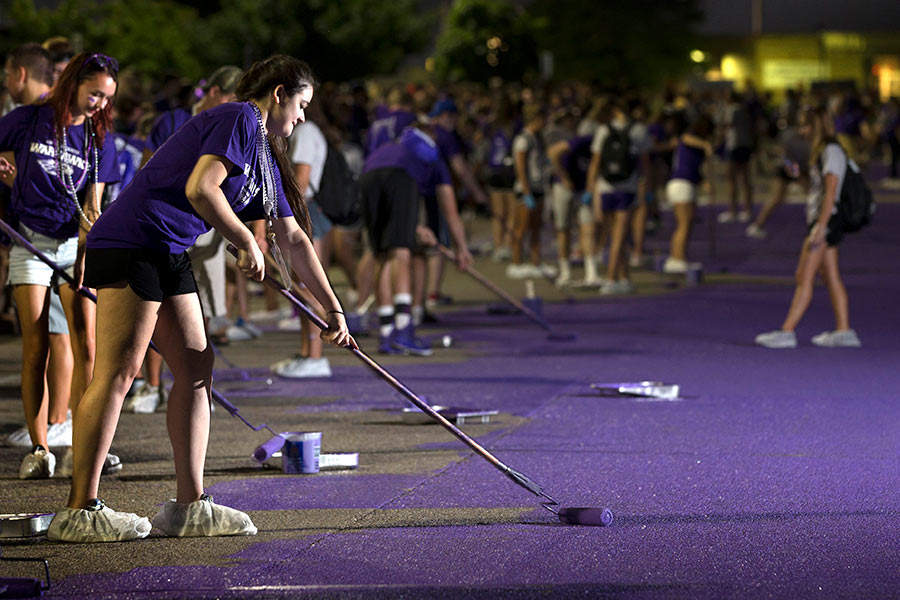 Students paiting the road purple for homecoming