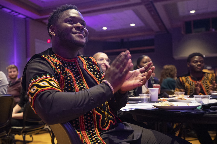 An international student from Nigeria claps during a performance in the University Center.