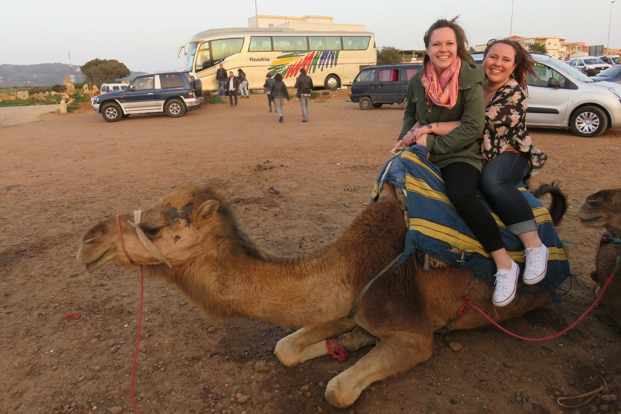 Two people sit on a camel.