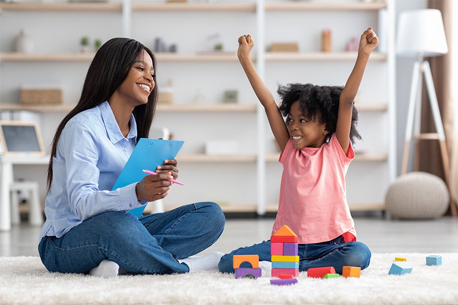 A school psychologist is teaching a child. Child is excited.