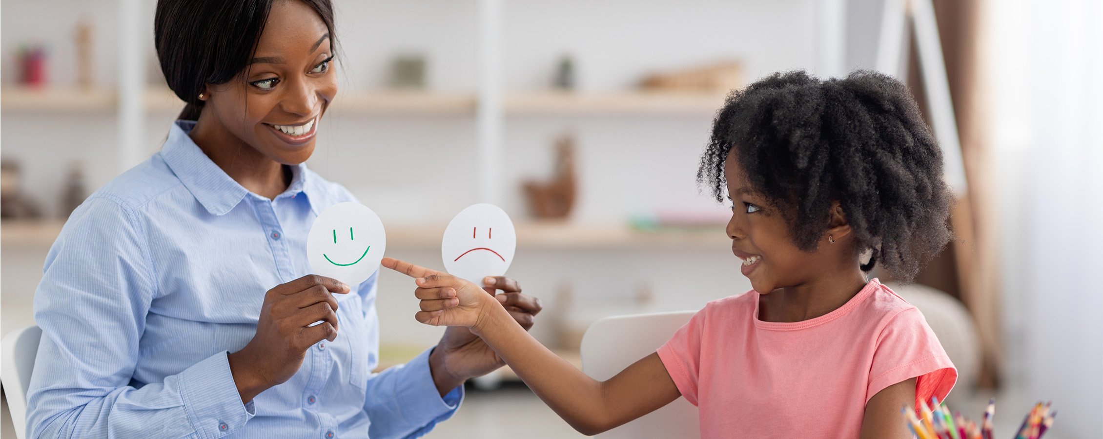 A school counselor working with a child in a classroom