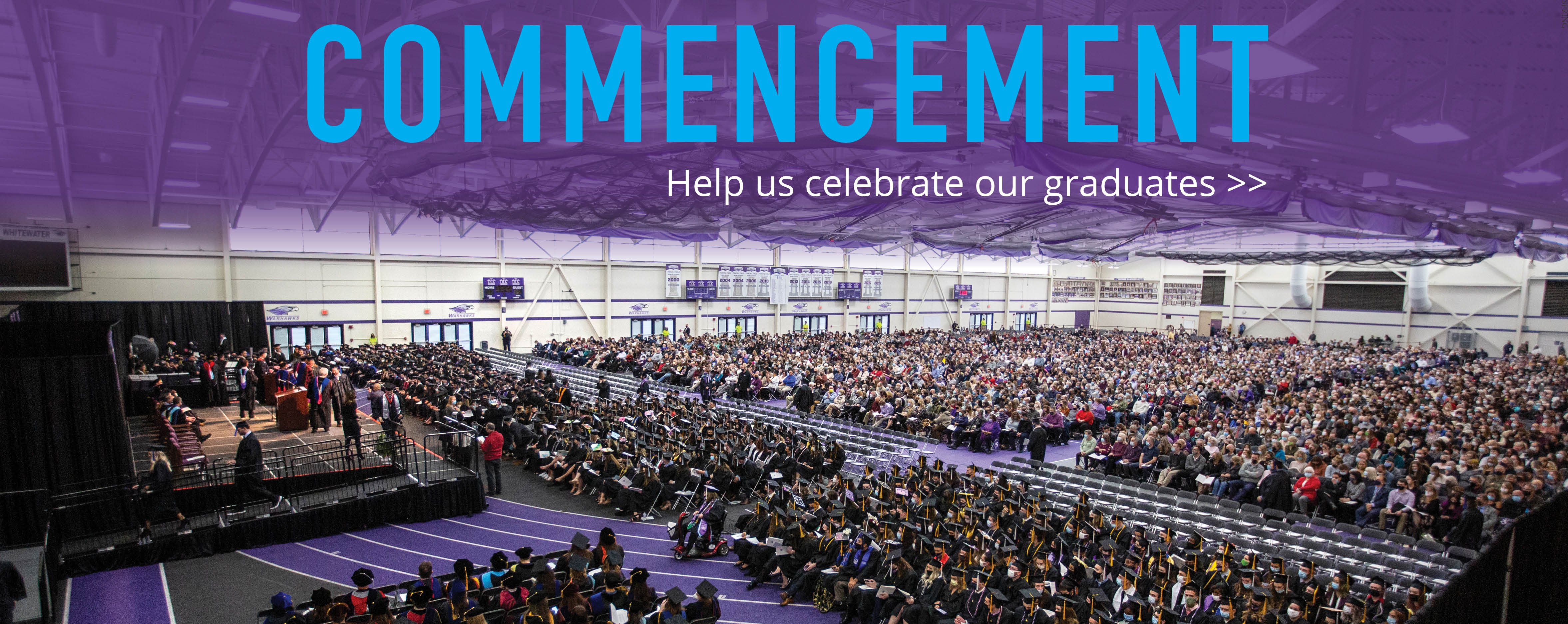 The fieldhouse is full of people during commencement.