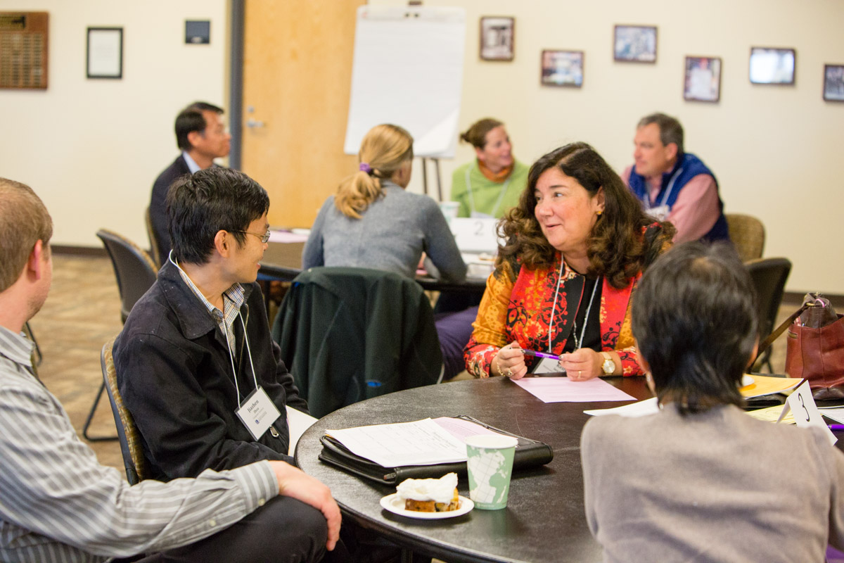 people talking in a group around a table