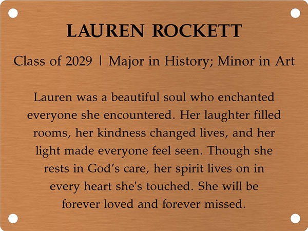 Copper memory wall plate that says Lauren Rockett. Class of 2029. Major in History; Minor in Art. Lauren was a beautiful soul who enchanted everyone she encountered. Her laughter filled rooms, her kindness changed lives, and her light made everyone feel seen. Though she rests in God’s care, her spirit lives on in every heart she's touched. She will be forever loved and forever missed.