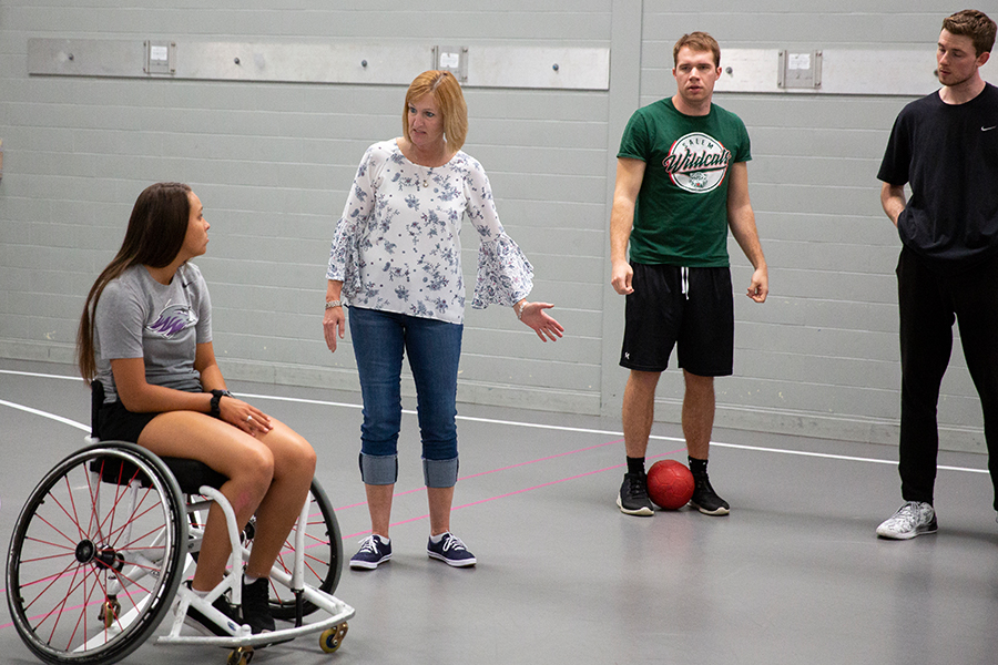 Kathleen Happel speaks with students in a gym on the UW-Whitewater campus.