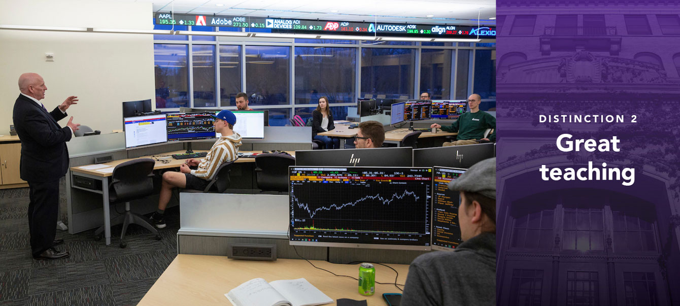 Finance and business law lecturer R.J. New, left, leads a discussion in the Hyland Hall trading room. New also serves as director for the Applied Investment Program.