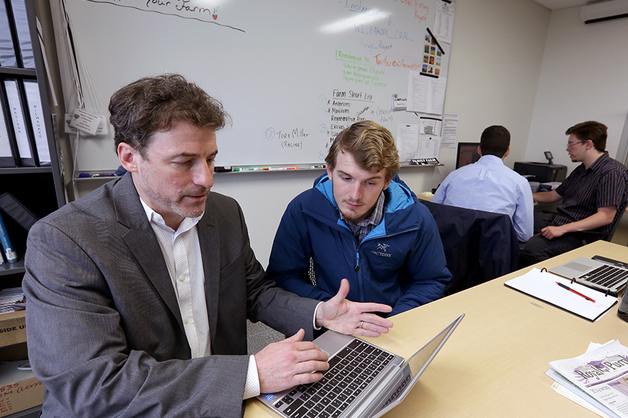 Man instructing student while they look at a laptop