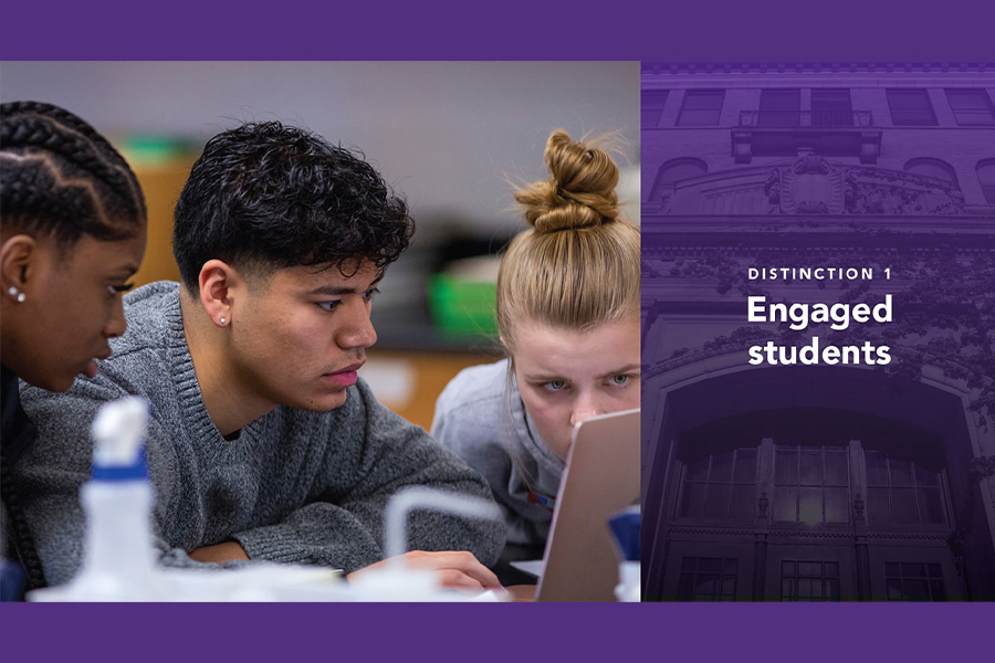 Three students work together on one laptop.