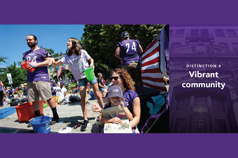 Several people sit together on a sidewalk while they watch a parade.