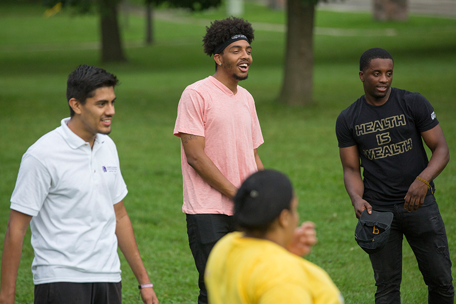 Group of UW-Whitewater students laughing outside at an event.