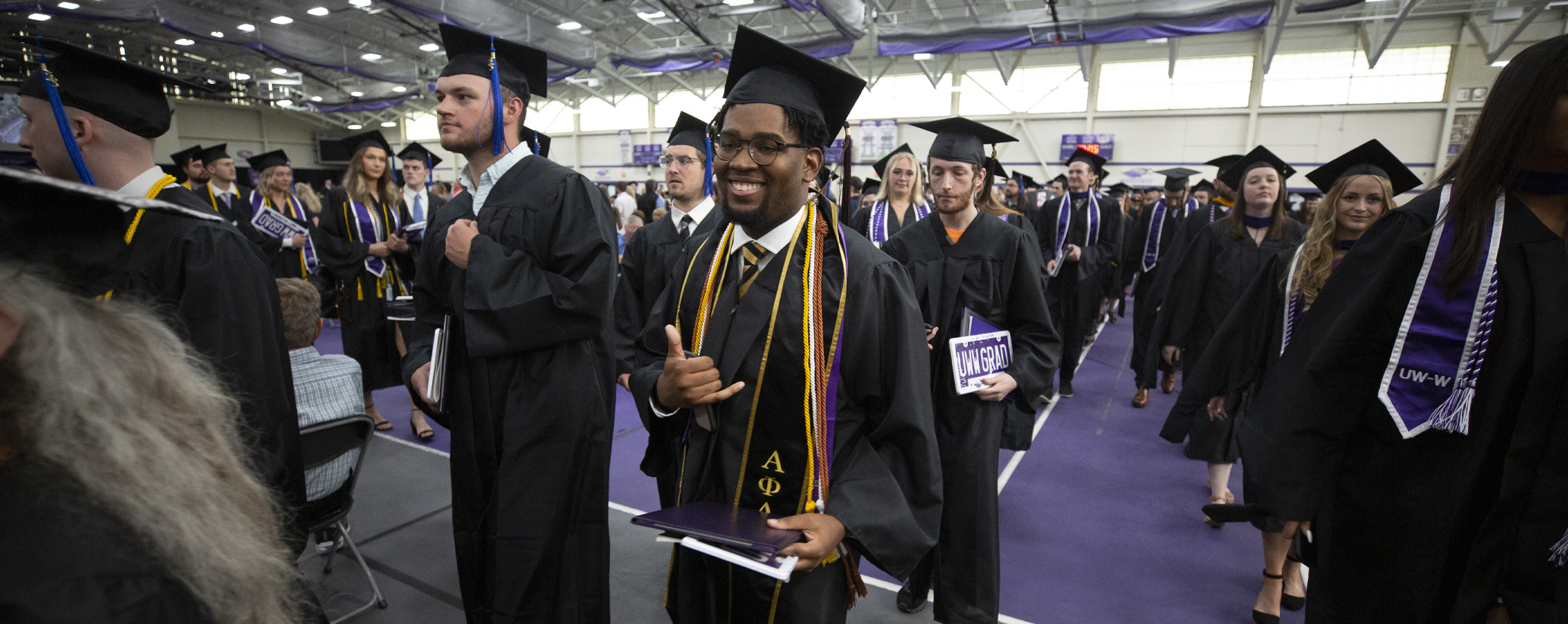 Graduates proceed down the aisles at Commencement in the fieldhouse.