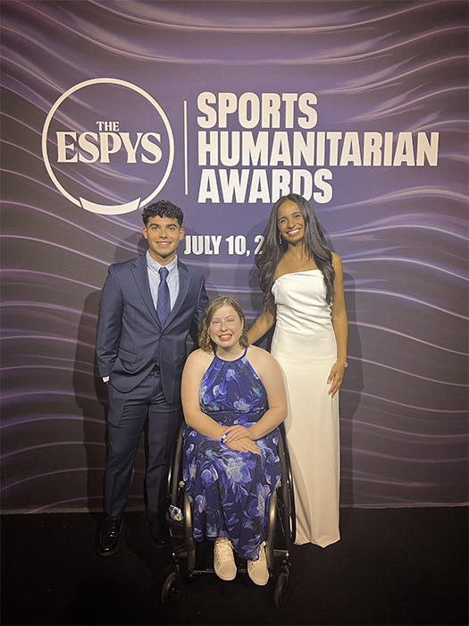 Hannah Smith poses with two other people in front of a banner that says The Espys Sports Humanitarian Awards.