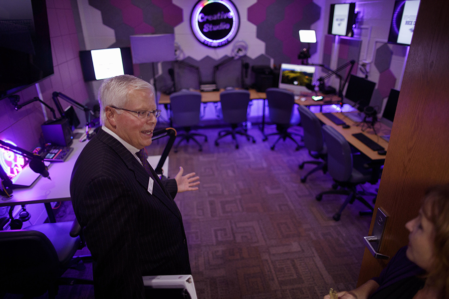 Jay Rothman stands in a classroom illuminated with purple lighting. 