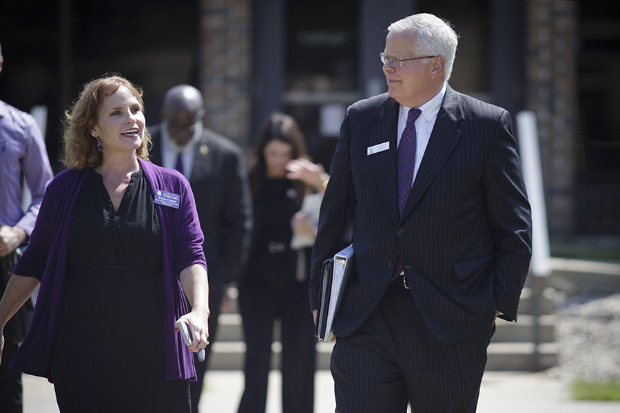 Tricia Clasen walks with Jay Rothman outdoors.