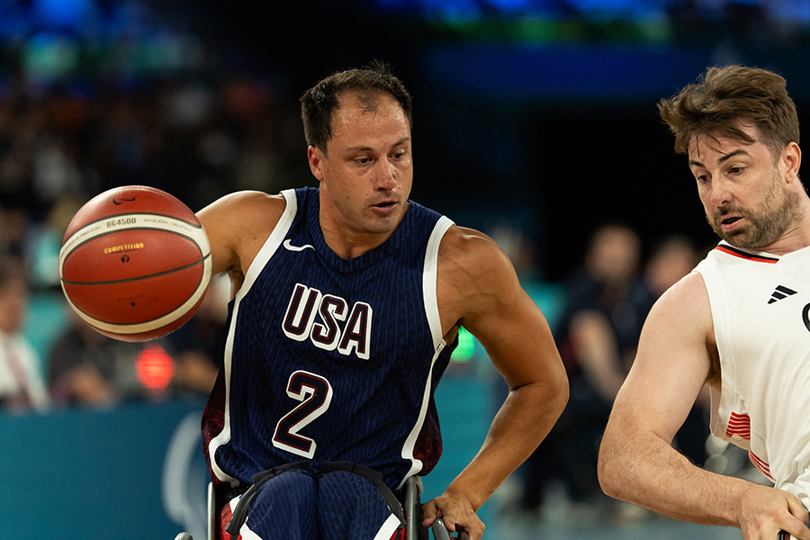 Jake Williams dribbles the ball with an opponent to his left. 