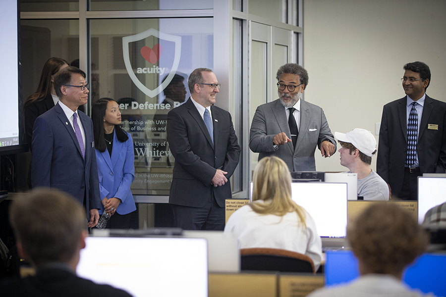 The National Cyber Director stands in front of a small crowd and talks with his hands.