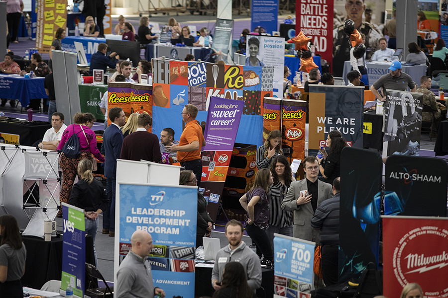 A busy picture shows lots of students and pop-up signs during a career fair.