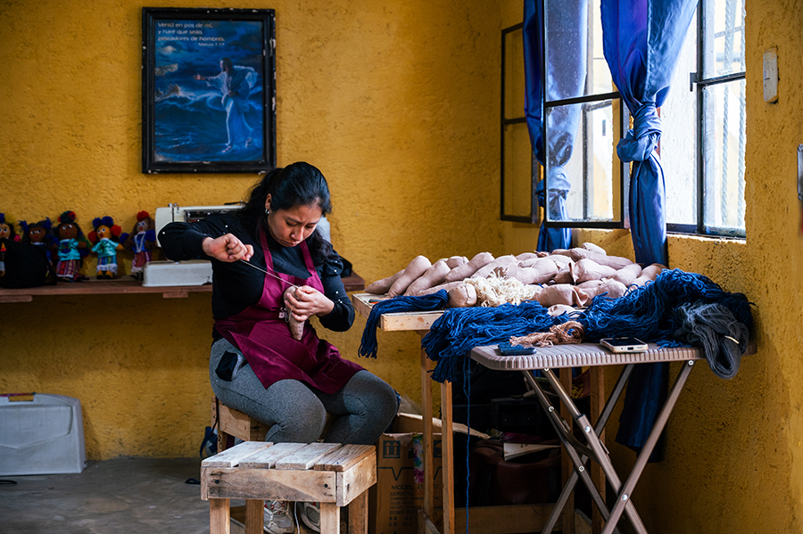 Una guatemalteca trabaja en una tienda haciendo muñecas. 