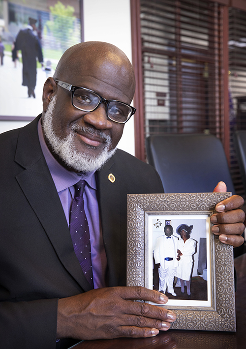 Corey King holds a framed photo of his parents.